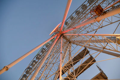 Low angle view of ferris wheel against clear blue sky