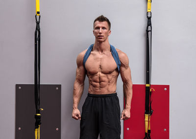 Full length of young man exercising in gym