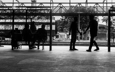 Silhouette people standing on railroad station platform