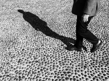 Low section of man walking on cobbled street