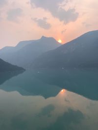 Scenic view of lake against mountains during sunset