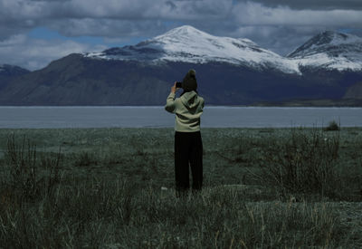 Rear view of woman standing on field