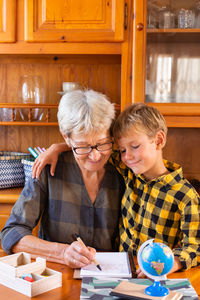 Homeschooling grandmother teaching kid, child, smart boy in geography. 