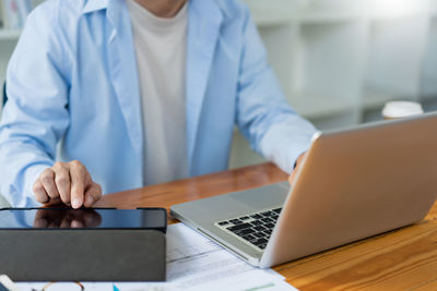 Midsection of businessman using laptop at office