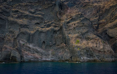 Close-up of cliff by sea