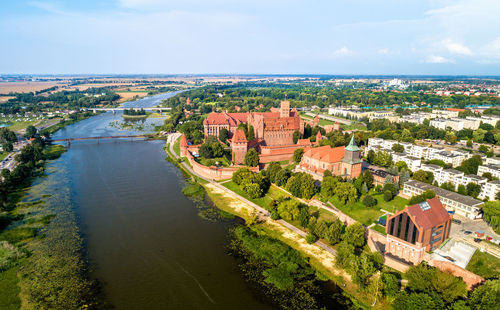 High angle view of river amidst buildings in town against sky