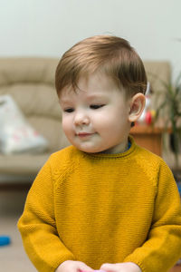 Little boy embarrassed in yellow jumper