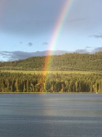 Scenic view of rainbow over landscape against sky