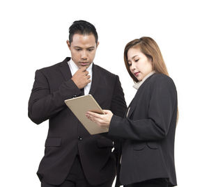 Young woman with arms raised against white background