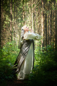 Rear view of woman standing in forest