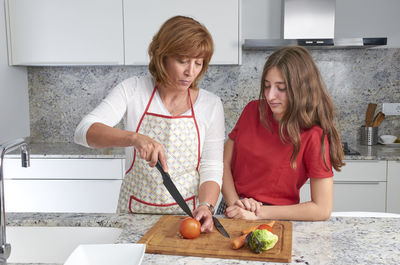 Friends standing on cutting board at home