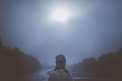 Woman standing by water against sky