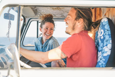 Happy couple sitting in caravan