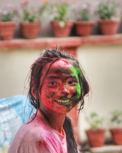 Portrait of smiling girl with powder paint on face during holi