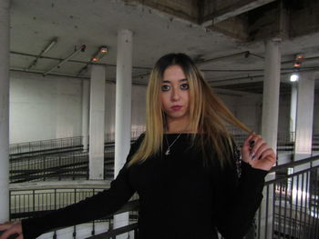 Portrait of beautiful young woman standing in building