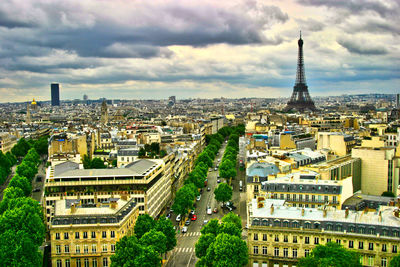 Eiffel tower in city against cloudy sky