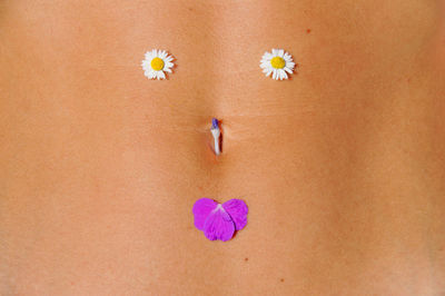 Midsection of woman with flowers on abdomen