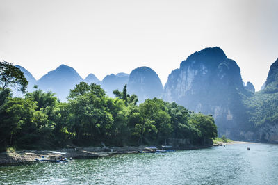 Scenic view of river and mountains against clear sky