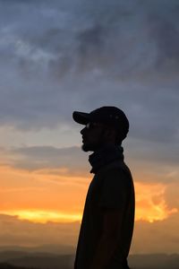 Silhouette man standing against orange sky