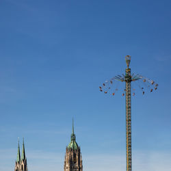 Low angle view of chain swing ride against clear blue sky