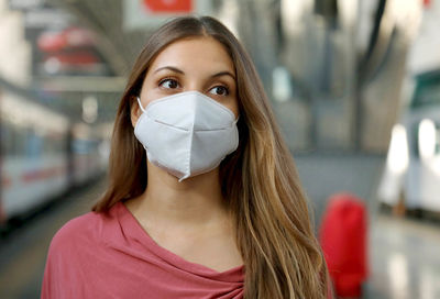 Close up of girl waiting metro wearing protective face mask at subway station