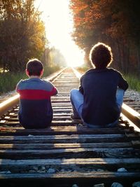 Rear view of men sitting on bench