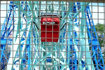 Ferris wheel seen through metal