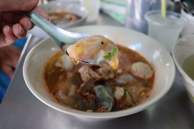 Close-up of hand holding soup in bowl