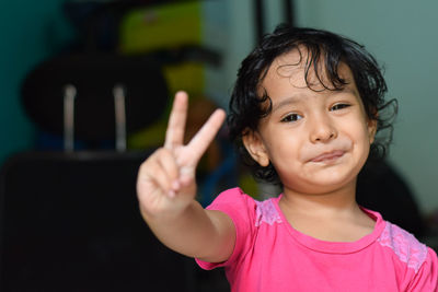 Portrait of smiling girl standing against pink background