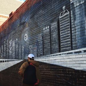 Optical illusion of man walking on road in city