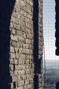 Close-up of brick wall with building in background