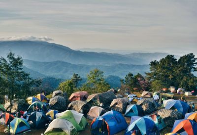 Tents on mountain against cloudy sky