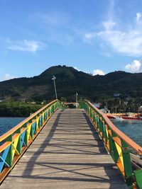 Footbridge amidst mountains against sky