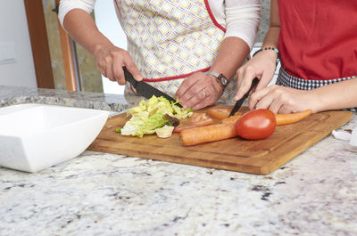 Midsection of woman holding ice cream on cutting board