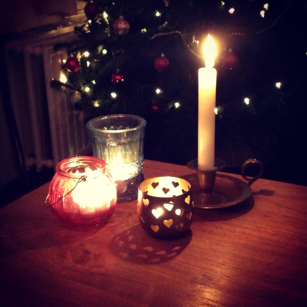 indoors, table, candle, illuminated, burning, still life, flame, glass - material, lit, close-up, focus on foreground, candlelight, lighting equipment, wineglass, food and drink, heat - temperature, wood - material, drink, glowing, home interior