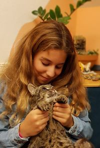 Cute girl sitting with cat at home