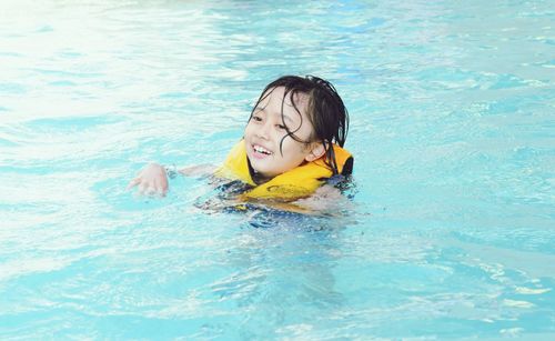 Happy girl swimming in pool