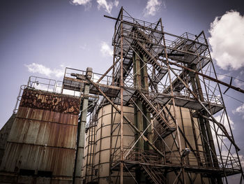 Low angle view of silos against sky