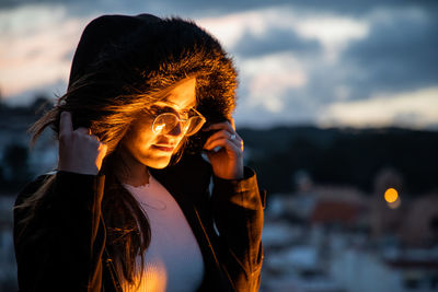 Portrait of beautiful woman against sky during sunset