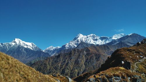 Scenic view of snowcapped mountains against clear blue sky
