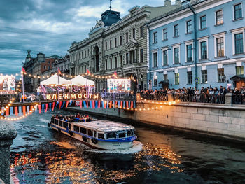 Boats in canal against buildings in city