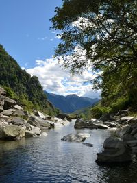 Scenic view of river and mountains against sky