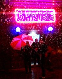 People walking on wet glass window at night