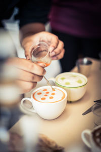 High angle view of barista mixing milk in drink at cafe