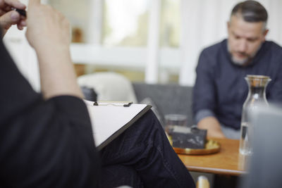 Cropped image of doctor with reports on clipboard during therapy session
