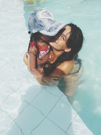 High angle portrait of woman with girl in swimming pool