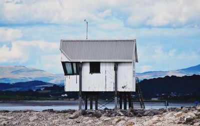 Lifeguard hut at beach against cloudy sky