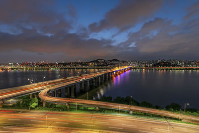 Illuminated light trails on road against sky at night