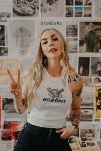 Portrait of young woman holding peace sign