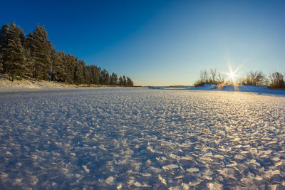 Scenic view of snow covered landscape against clear blue sky